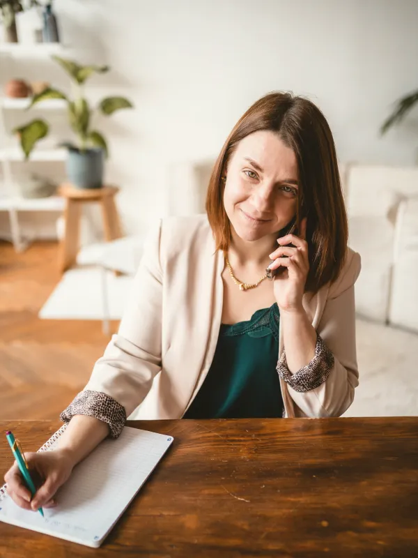 Anastasia téléphone en prenant des notes au bureau